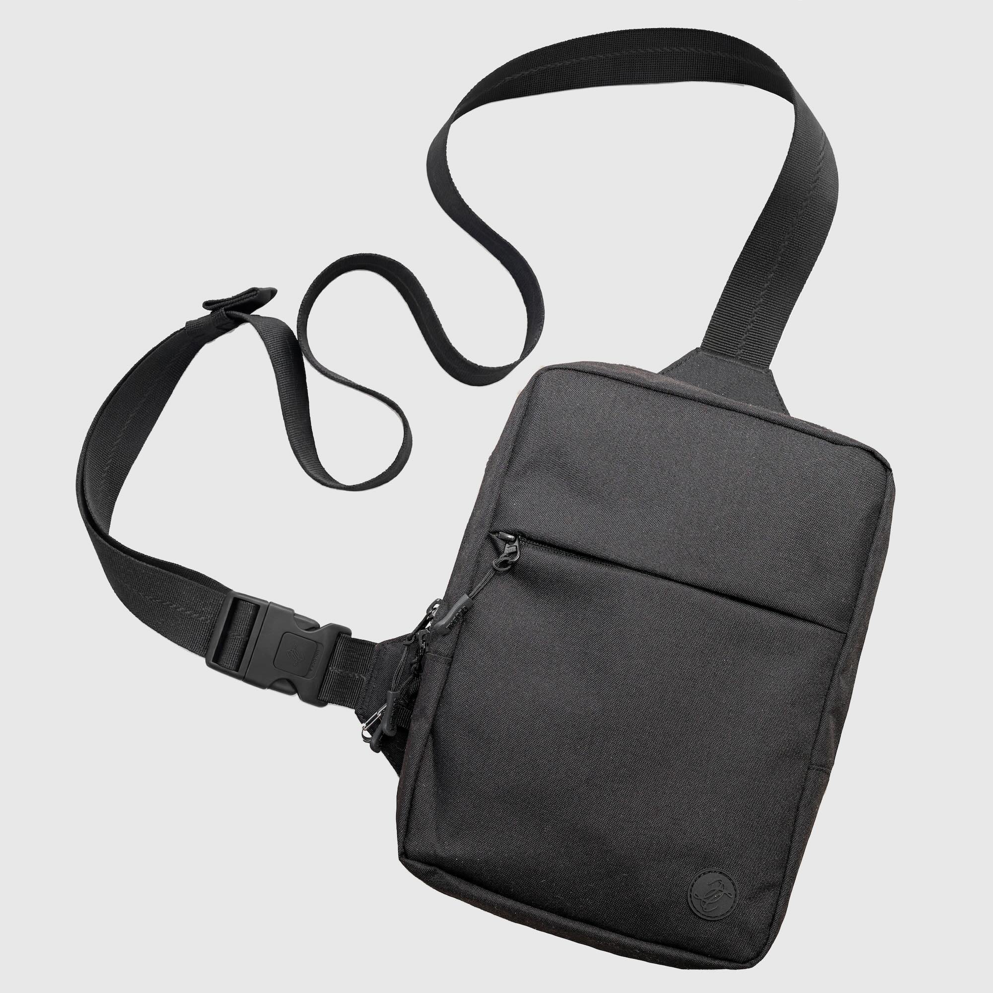 Black shoulder bag with a strap on a light gray background