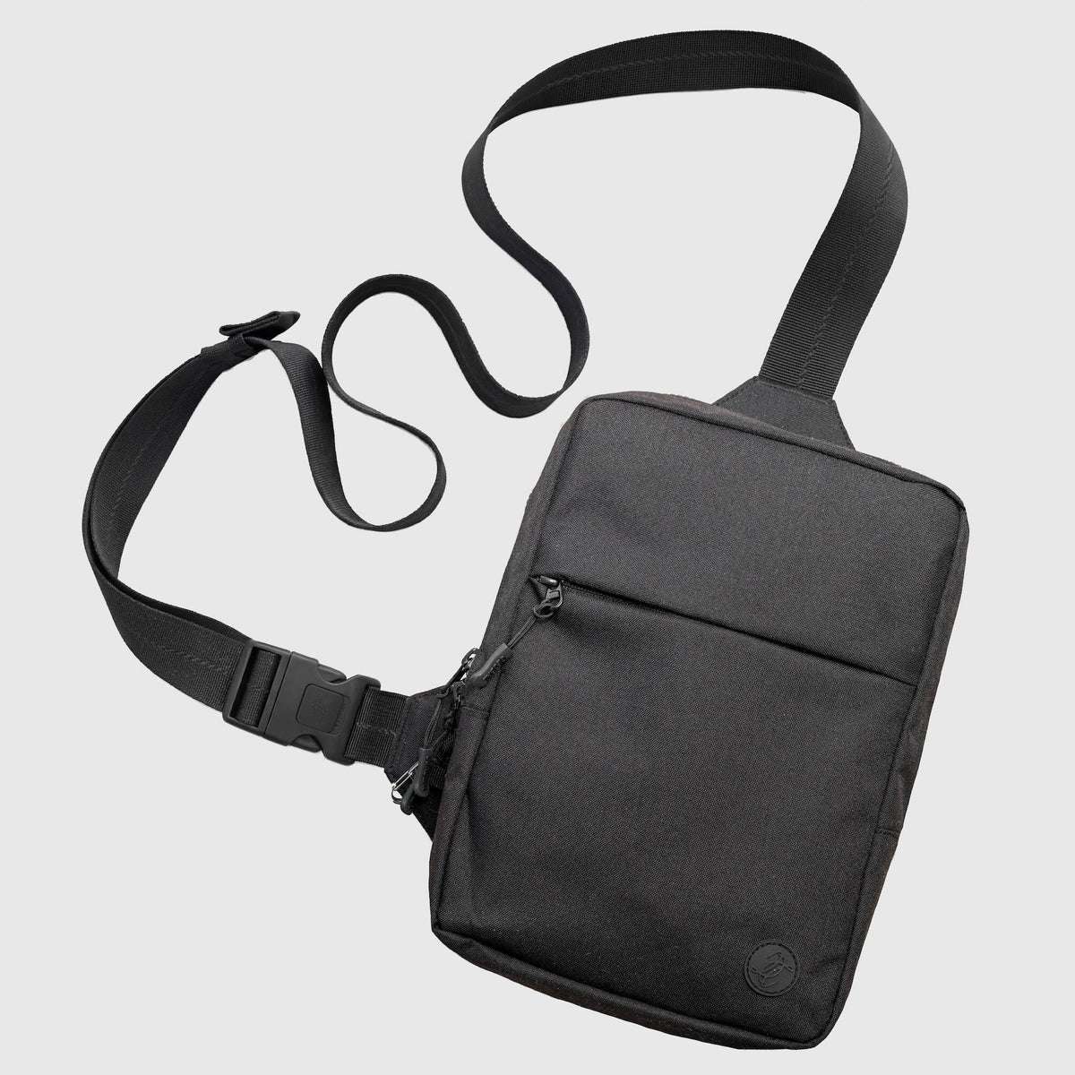 Black shoulder bag with a strap on a light gray background