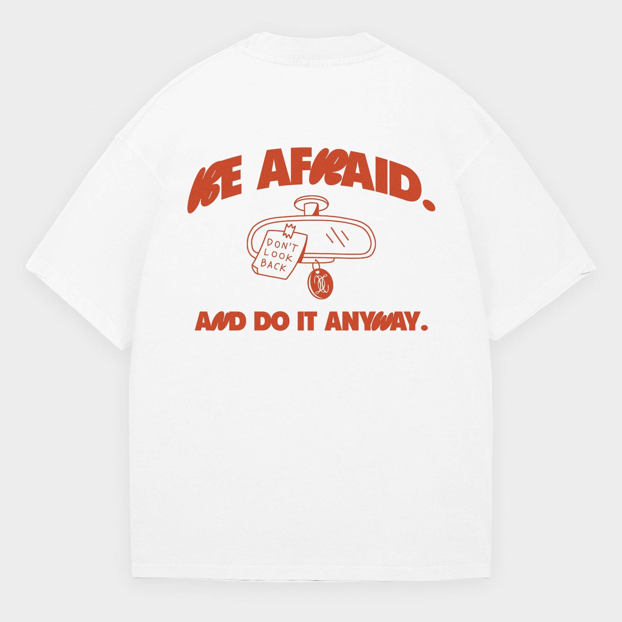 White t-shirt with red text and graphic design on a white background with a text Be Afraid and Do it anyway.